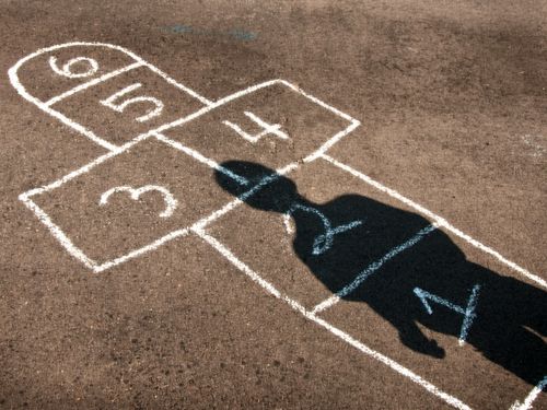 Image of a person's shadow on hopscotch