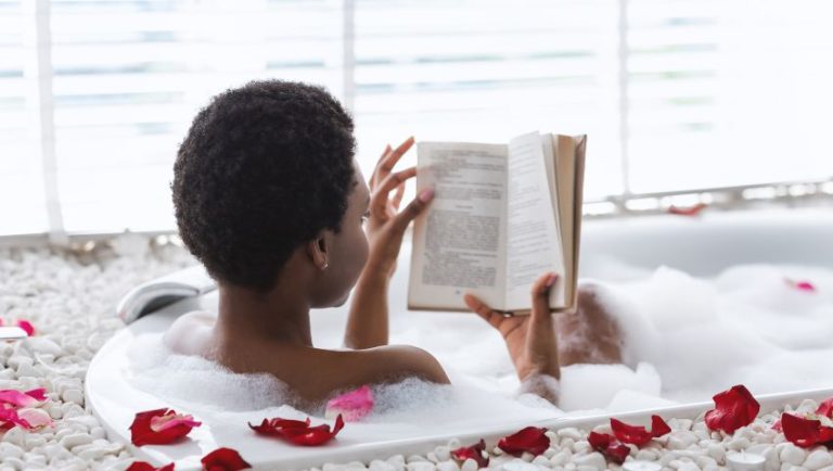 Image of woman in bubble bath reading a book