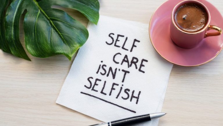 Image of sign saying slef care isn't selfish with a cup of coffee and a leaf